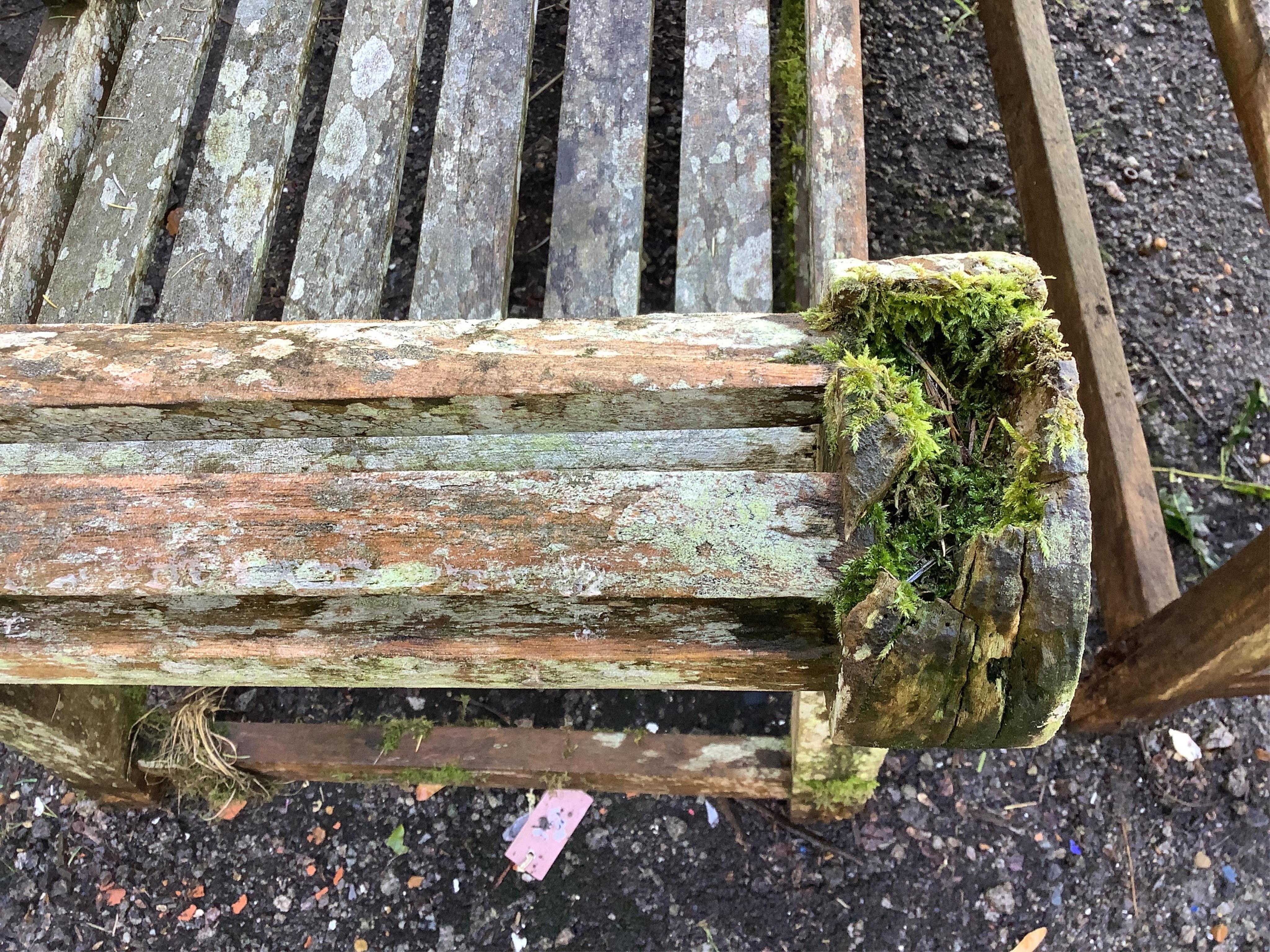 A weathered teak Lutyens style garden bench, width 165cm, depth 58cm, height 103cm. Condition - poor, covered in lichen